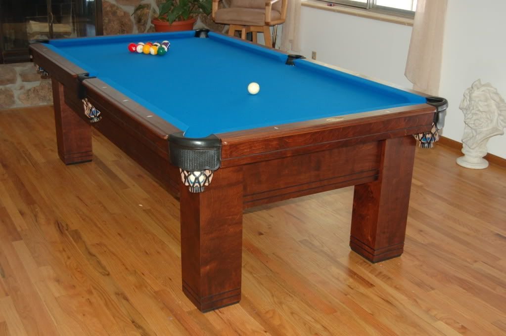 Luxury pool table with blue felt and decorative pockets, set in a well-lit room, showcasing craftsmanship relevant to The Billiard Broker's offerings in Peoria, AZ.